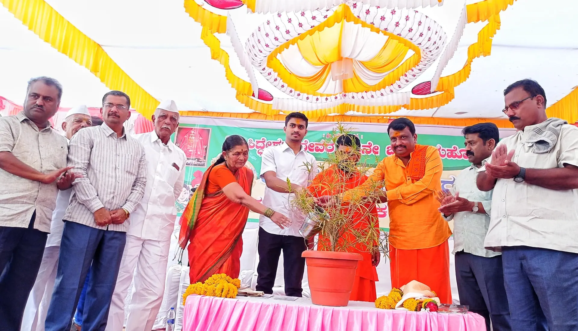 ಸಾರ್ವಜನಿಕ ಕಾರ್ಯಕ್ರಮದ ವೇದಿಕೆಯಲ್ಲಿ ಗಿಡಕ್ಕೆ ನೀರೆರೆಯುತ್ತಿರುವ ರಾಹುಲ್ ಜಾರಕಿಹೊಳಿ ಮತ್ತು ಭಾಗವಹಿಸಿದವರು